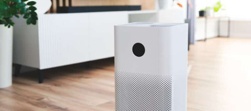 closeup of an air purification system sitting on the floor of a residential home next to a white couch